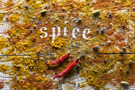 Top view on scattered spices on table with chili peppers and word Spiceの写真素材