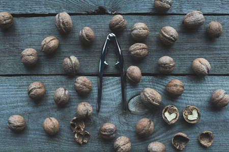 top view of organic walnuts and nutcracker on wooden tableの写真素材