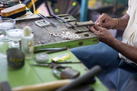 cropped shot of oriental jewelry master making rings at sri lanka manufactureの写真素材