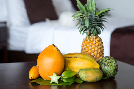 tropical fruits composition on table at hotel roomの写真素材