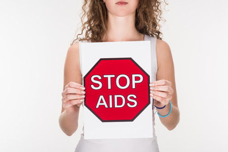 cropped view of woman holding stop aids sign, isolated on whiteの写真素材