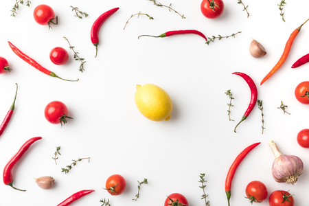 lemon among chili peppers and tomatoesの写真素材