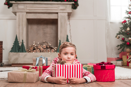 boy laying on floor with christmas giftsの写真素材