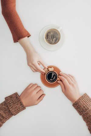 human hands and cups of coffee with sugar on whiteの写真素材