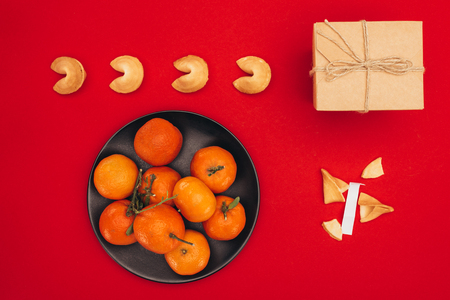 chinese fortune cookies and tangerines on red surface as chinese new year compositionの写真素材
