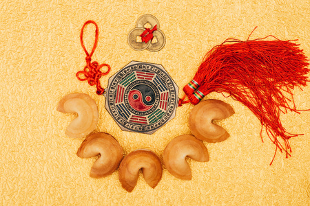 chinese talisman surrounded with fortune cookies on golden surface, Chinese New Year conceptの写真素材