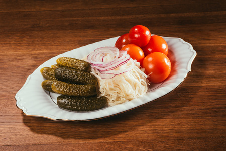 pickled vegetables on white plate on wooden tableの写真素材