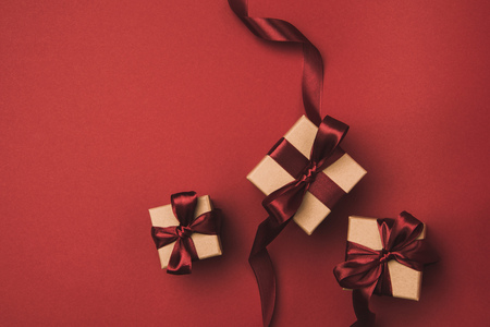 flat lay with arrangement of gifts decorated with ribbons isolated on redの写真素材