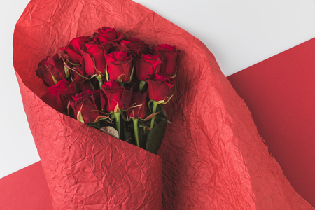 top view of bouquet of roses in red wrapping paper isolated on whiteの写真素材