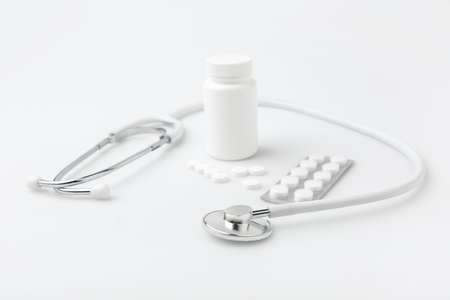 stethoscope,scattered pills and another tablets in package and in plastic canの写真素材