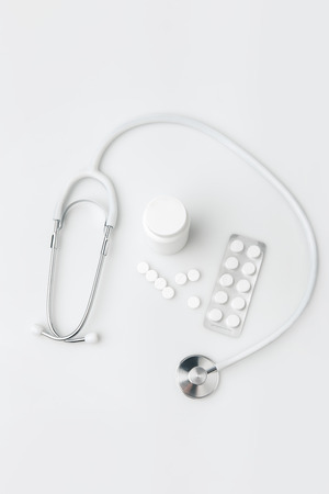 stethoscope,scattered pills and another tablets in package and in plastic canの写真素材