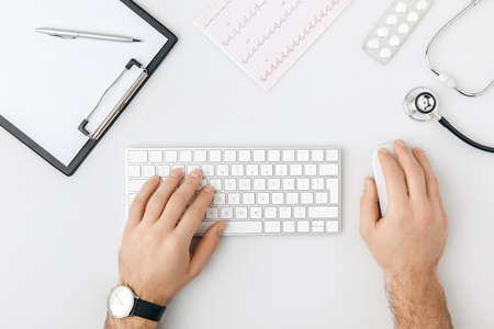 top view of hand with wristwatch on keyboard