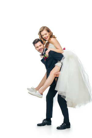 side view of groom and bride piggybacking togetherの写真素材