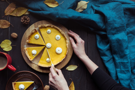 female hands cutting pumpkin tartの写真素材