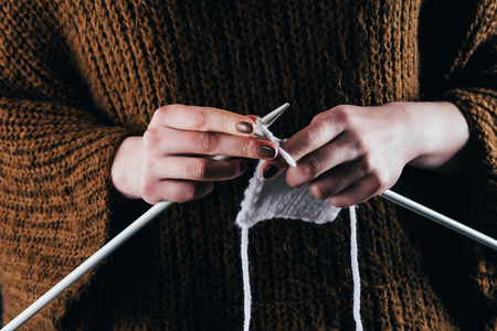 cropped view of woman knitting wool with needlesの写真素材