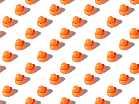 seamless pattern of small orange rubber ducks on whiteの写真素材