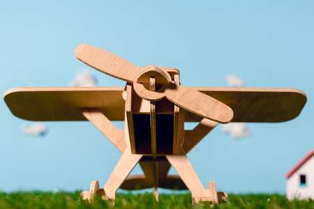 wooden toy plane on green grassの写真素材