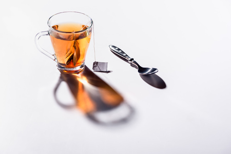 glass cup of black tea and spoonの写真素材