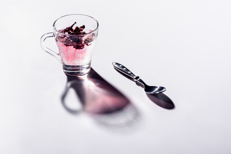 glass cup of hibiscus tea with spoonの写真素材