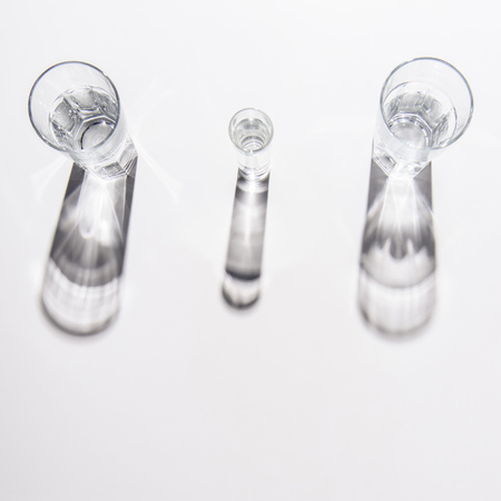 different sized glasses with water on white table