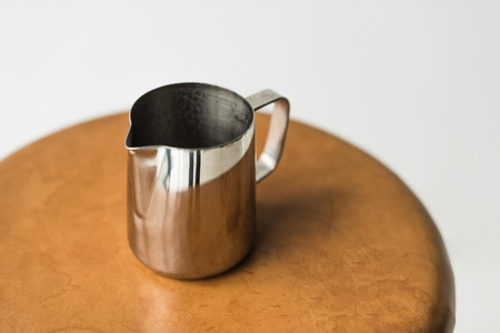 high angle view of stainless milk pitcher on wooden chairの写真素材