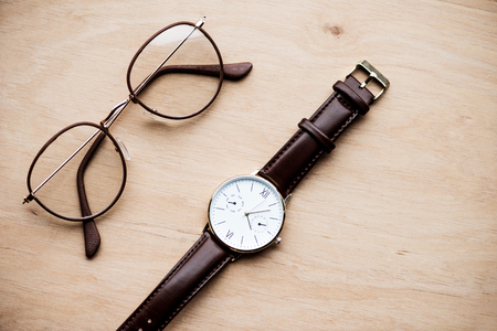 Glasses and watch on wooden surfaceの写真素材