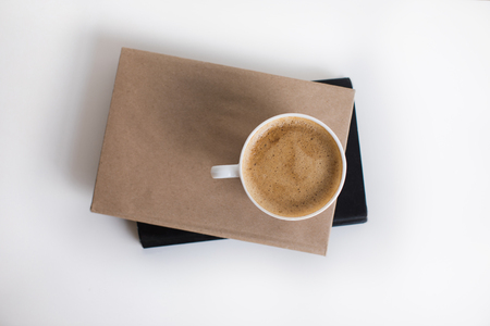top view of white cup of coffee on two booksの写真素材