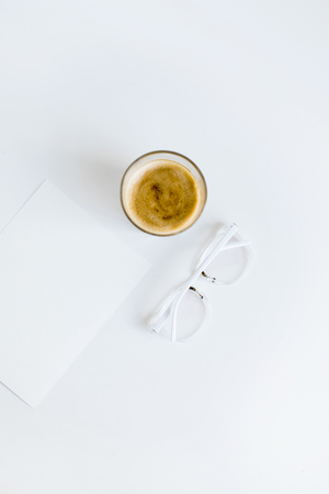 top view of cup of coffee, white paper with eyeglassesの写真素材