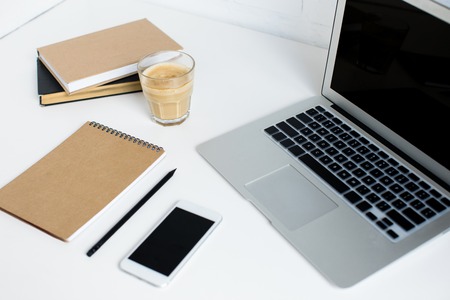 laptop, smartphone, notepad, books and glass of coffeeの写真素材