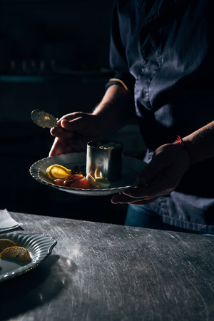 chef preparing salad with metal forming tubeの写真素材