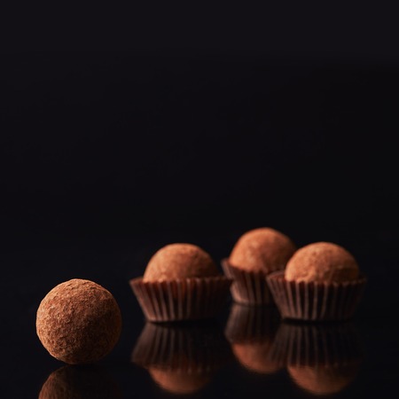 close up view of tasty truffles on blackの写真素材