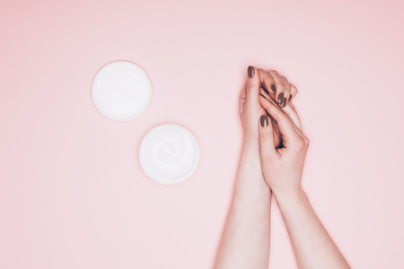 cropped shot of woman applying hand cream isolated on pinkの写真素材