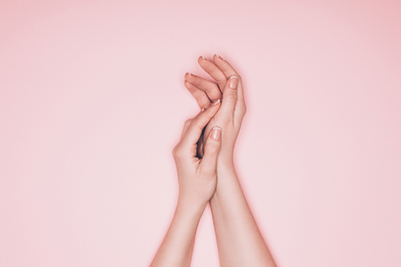 cropped shot of female hands with perfect skin isolated on pinkの写真素材