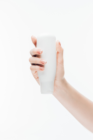 cropped shot of woman holding bottle of lotion in hand isolated on whiteの写真素材