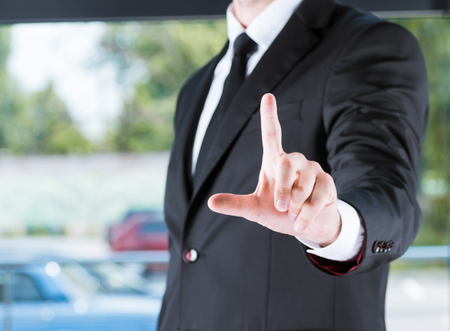 businessman in black suit pointing with fingerの写真素材