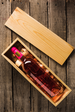 top view of bottle of pink wine in wooden box on tabletop with copy spaceの写真素材