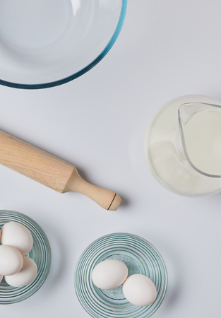 top view of eggs, milk and rolling pin on tableの写真素材