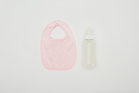 top view of baby bib and bottle of milk