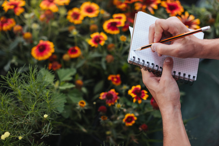 gardener making notes in notebook in gardenの写真素材