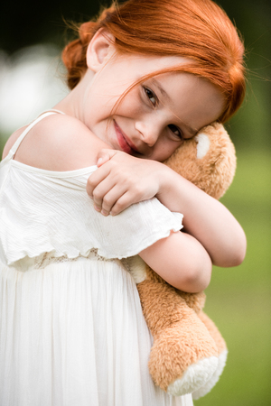 redhead girl with teddy bearの写真素材
