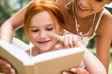 mother and daughter reading bookの写真素材