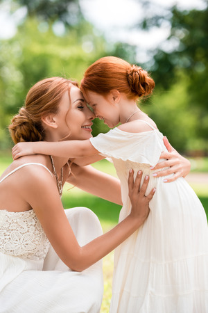 mother and daughter hugging at parkの写真素材
