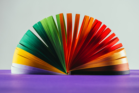 colored quilling paper curves on purple surface on whiteの写真素材