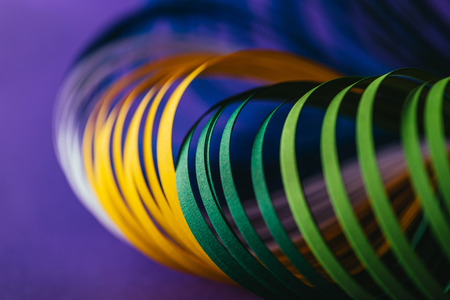 close up of colored quilling paper curves on purple