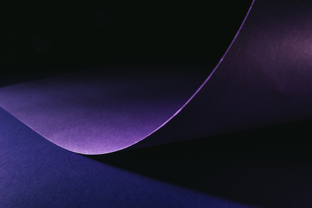 warping purple paper on purple surface on blackの写真素材