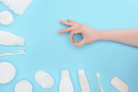 Cropped view of woman with ok sign isolated on blue with cosmetic creamの写真素材