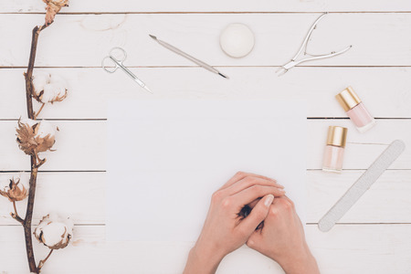 Woman sitting at table with manicure toolsの写真素材