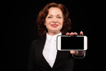 Businesswoman showing smartphone screenの写真素材