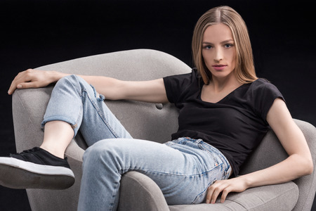 young woman sitting in armchairの写真素材