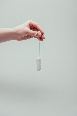 cropped shot of woman holding tampon in hand